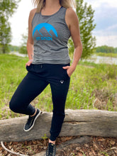 Load image into Gallery viewer, grey unisex tank with blue gtf outside logo with sun and mountains. ladies black athletic pants. joggers. men. gtfo.
