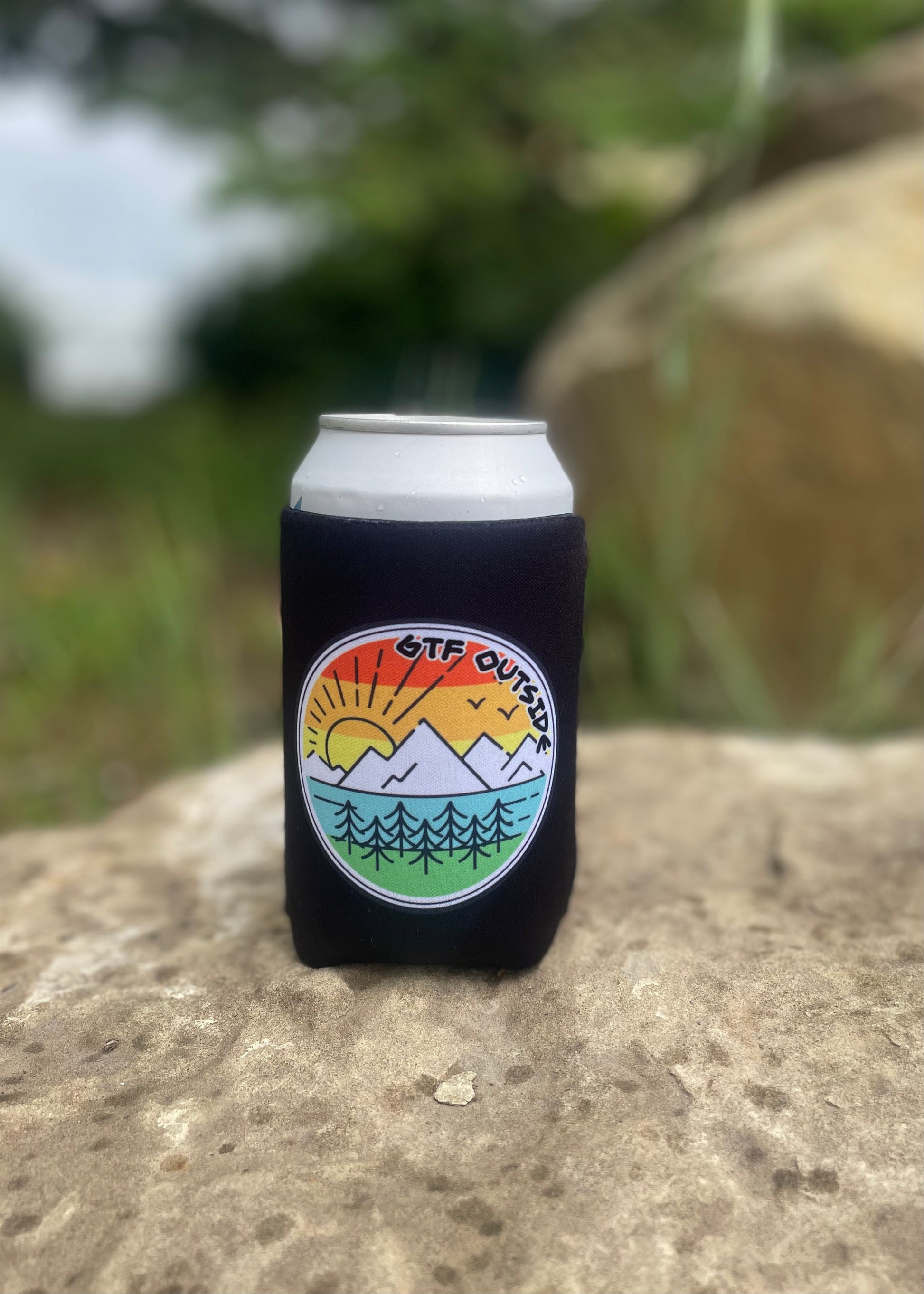 black koozie with gtf outside logo. gtfo. sunrise logo with sun, mountains and trees